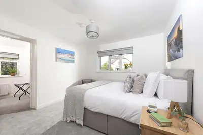 a bedroom with a bed and a desk and windows at Tre Lowen, Goonhavern, Perranporth - Free Parking - Free Wifi - Games Room in Perranporth