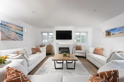 a living room with white furniture and a flat screen tv at Tre Lowen, Goonhavern, Perranporth - Free Parking - Free Wifi - Games Room in Perranporth