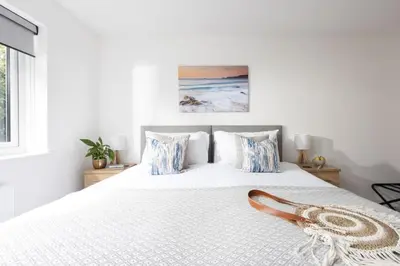 a bedroom with a white bed with blue pillows at Tre Lowen, Goonhavern, Perranporth - Free Parking - Free Wifi - Games Room in Perranporth
