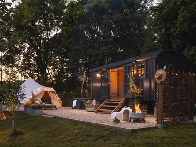 a black tiny house in a yard with a tent at Moonshine in Truro