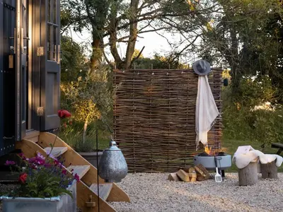 a backyard with a wooden fence and a fire place at Moonshine in Truro