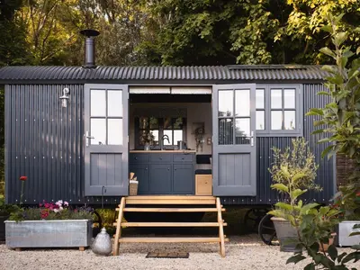 a black and white shed with a bench in a yard at Moonshine in Truro