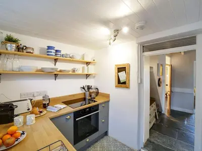 a kitchen with a sink and a counter with oranges on it at St Peters Cottage in Port Isaac
