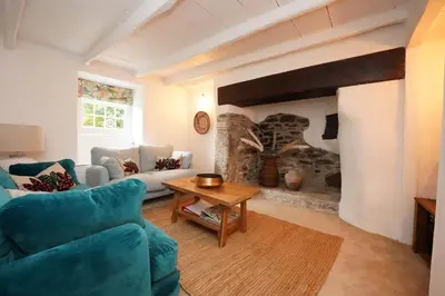 a living room with a couch and a table at Finest Retreats - Old Lanvean Cottage in Saint Mawgan