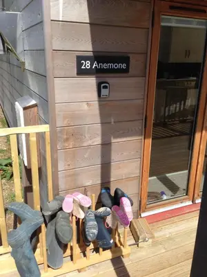 a group of shoes on a rack in front of a door at Anemone in Porthtowan