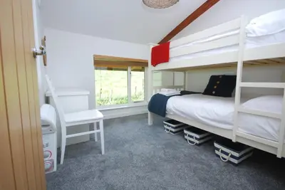 a bedroom with two bunk beds and a window at Anemone in Porthtowan