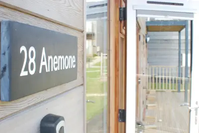 a door with a sign that reads entrance at Anemone in Porthtowan