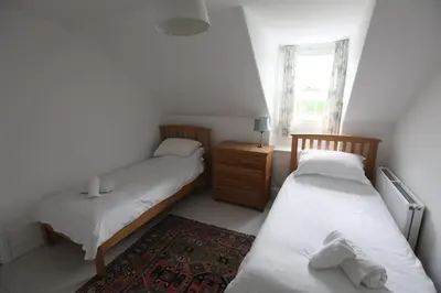 a bedroom with two beds and a window at Sea Haven in Port Isaac