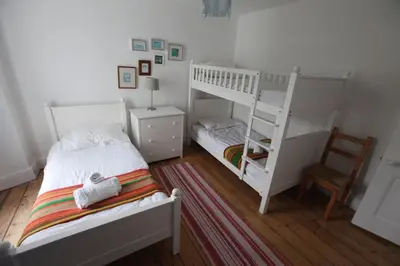 a bedroom with two bunk beds and a chair at Sea Haven in Port Isaac