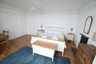 a bedroom with a bed and a table in it at Sea Haven in Port Isaac