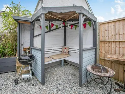 a bed in a gazebo in a garden at Lanner Moon in Carnbrea