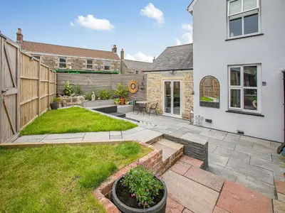 a garden with a patio and a house at Lanner Moon in Carnbrea