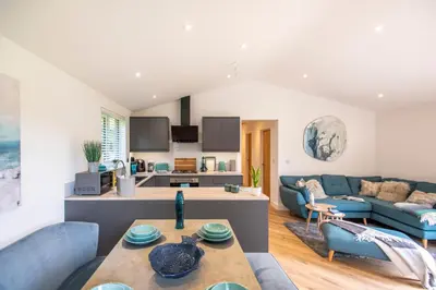 a living room with a couch and a table at Maple Lodge in Hayle