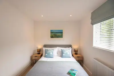 a small bedroom with a bed and two night stands at Maple Lodge in Hayle