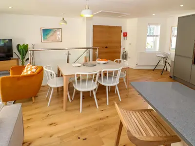 a kitchen and dining room with a table and chairs at Sea La Vie in St Ives