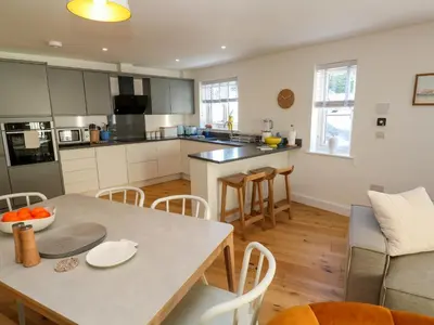 a kitchen and living room with a table and chairs at Sea La Vie in St Ives