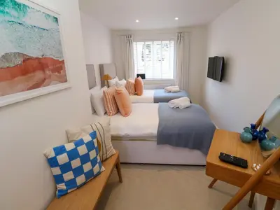 two beds in a room with a couch and a table at Sea La Vie in St Ives