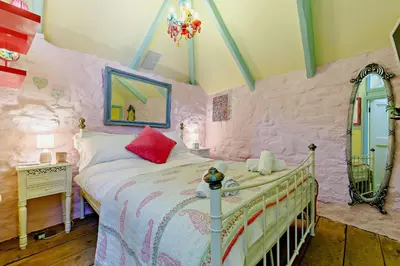 a pink bedroom with a bed and a mirror at 1 Bed in St. Ives oc-e28023 in St Ives