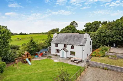 an aerial view of a white house with a playground at 5 Bed in Bodmin oc-l29658 in Blisland