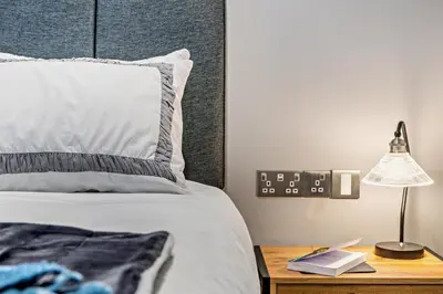 a bedroom with a bed and a nightstand with a lamp at 3 Bed in Fowey oc-p29280 in Fowey