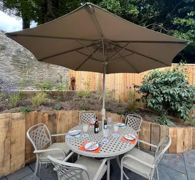 a table and chairs with an umbrella on a patio at 3 Bed in Fowey oc-p29280 in Fowey