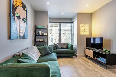 a living room with a green couch and a television at 3 Bed in Fowey oc-p29280 in Fowey