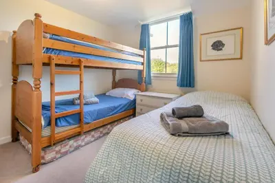 a bedroom with two bunk beds and a window at 3 Bed in St. Minver oc-c29337 in Saint Minver