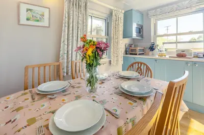 a kitchen with a table with plates and flowers on it at 3 Bed in St. Minver oc-c29337 in Saint Minver