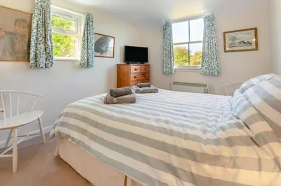 a bedroom with a bed and two windows at 3 Bed in St. Minver oc-c29337 in Saint Minver