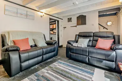 two leather couches sitting in a living room at 2 Bed in Delabole oc-r29780 in Delabole