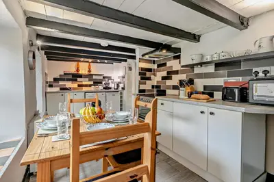 a kitchen with a wooden table and a counter top at 2 Bed in Delabole oc-r29780 in Delabole