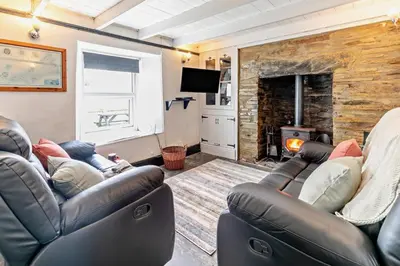 a living room with two leather couches and a tv at 2 Bed in Delabole oc-r29780 in Delabole