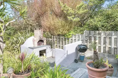 a backyard with a pizza oven and a fence at 4 Bed in Mawgan Porth oc-h29763 in Mawgan Porth