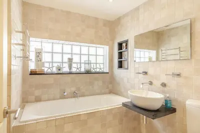 a bathroom with a tub and a sink and a window at 4 Bed in Mawgan Porth oc-h29763 in Mawgan Porth