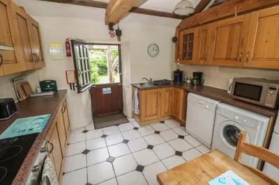 a kitchen with a washer and dryer in it at Horseshoe Cottage in Newquay
