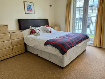 a bedroom with a bed and a dresser and a window at 79 Atlantic Reach in Newquay