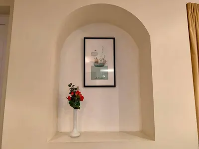 a vase with flowers in a niche with a picture at 79 Atlantic Reach in Newquay