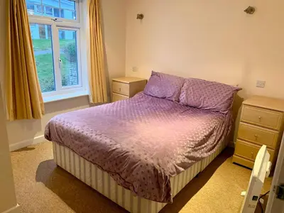 a bedroom with a bed with purple sheets and a window at 79 Atlantic Reach in Newquay