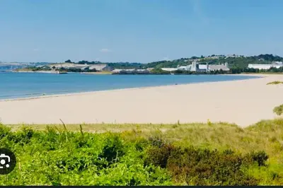 a view of a beach with the ocean in the background at The Driftwood Den in Tywardreath