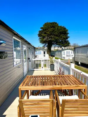 a wooden deck with two benches on a house at The Driftwood Den in Tywardreath