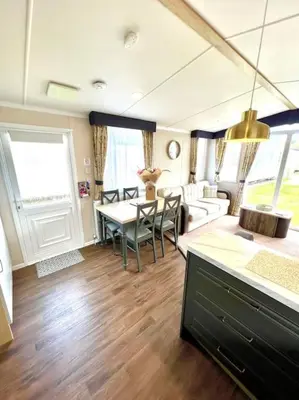 a living room with a table and a couch at The Driftwood Den in Tywardreath