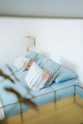a blue bed with pillows on top of it at Stunning High Street Townhouse With Sea Views & Parking at 'Tide View Townhouse' in Falmouth