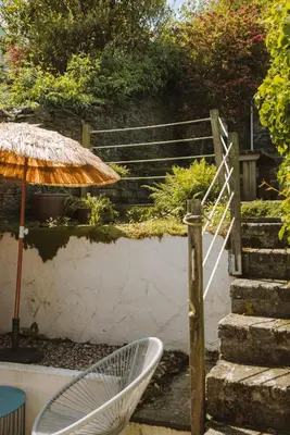 a chair and an umbrella next to some stairs at Stunning High Street Townhouse With Sea Views & Parking at 'Tide View Townhouse' in Falmouth