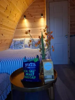 a small table with a bed in a room at Beautiful and Cosy Garden Pod Saintives in Carbis Bay