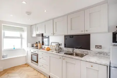 a white kitchen with white cabinets and a sink at 2 Bed in Porthleven oc-m28188 in Porthleven