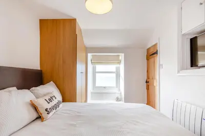 a bedroom with a white bed and a window at 2 Bed in Porthleven oc-m28188 in Porthleven