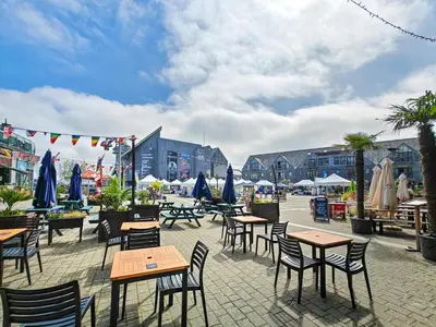 an outdoor patio with tables and chairs and umbrellas at 3 Bed in Goldenbank oc-c29977 in Falmouth
