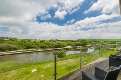 a balcony with chairs and a view of a river at 6 Bed in Winnards Perch oc-t29966 in Saint Columb Major
