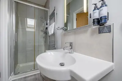 a white bathroom with a sink and a shower at 6 Bed in Winnards Perch oc-t29966 in Saint Columb Major