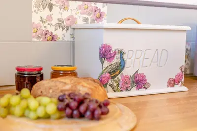 a plate of grapes and a bread with a sign at 2 Bed in Trewoon oc-t29504 in St Austell